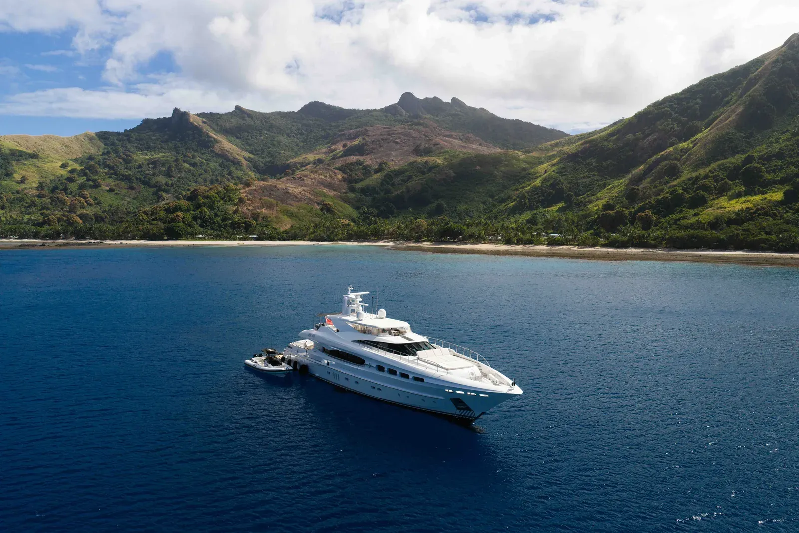 M/Y Impulsive at anchor beneath the hills of a Fijian island
